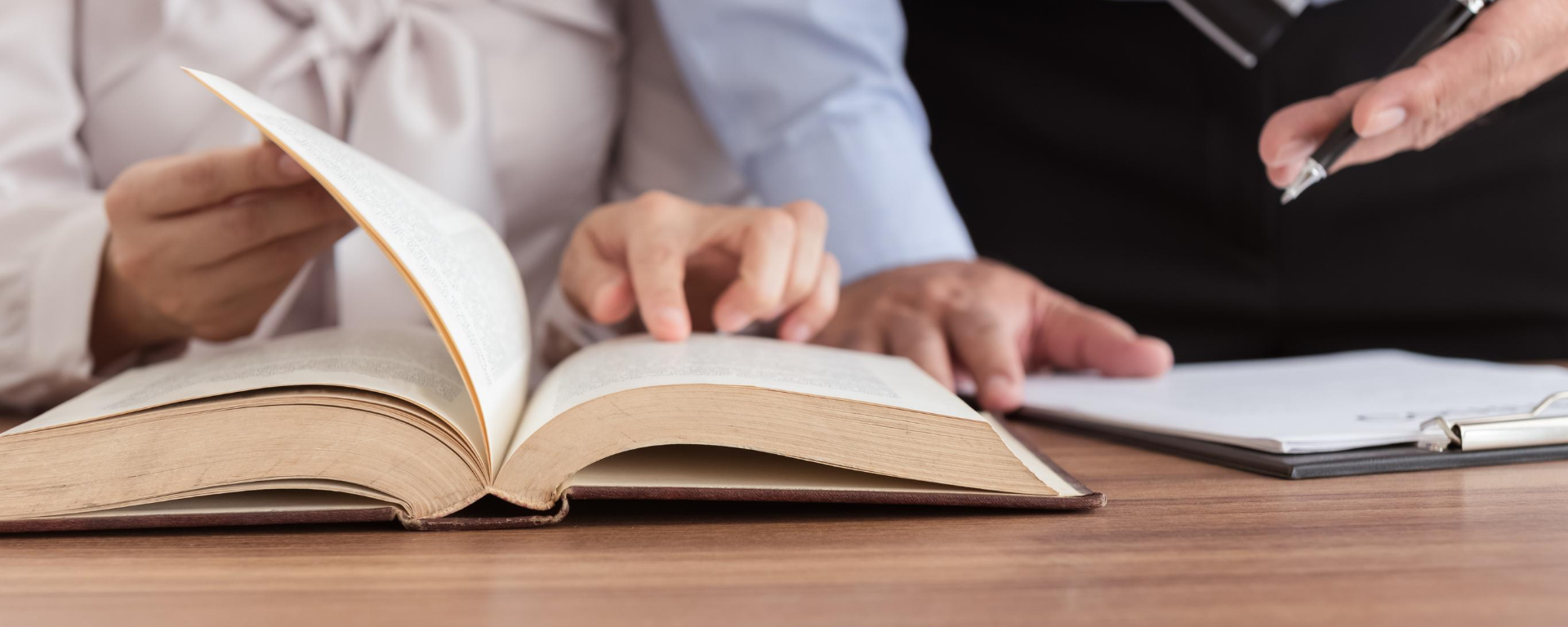 Una mujer señala una hoja de un libro.