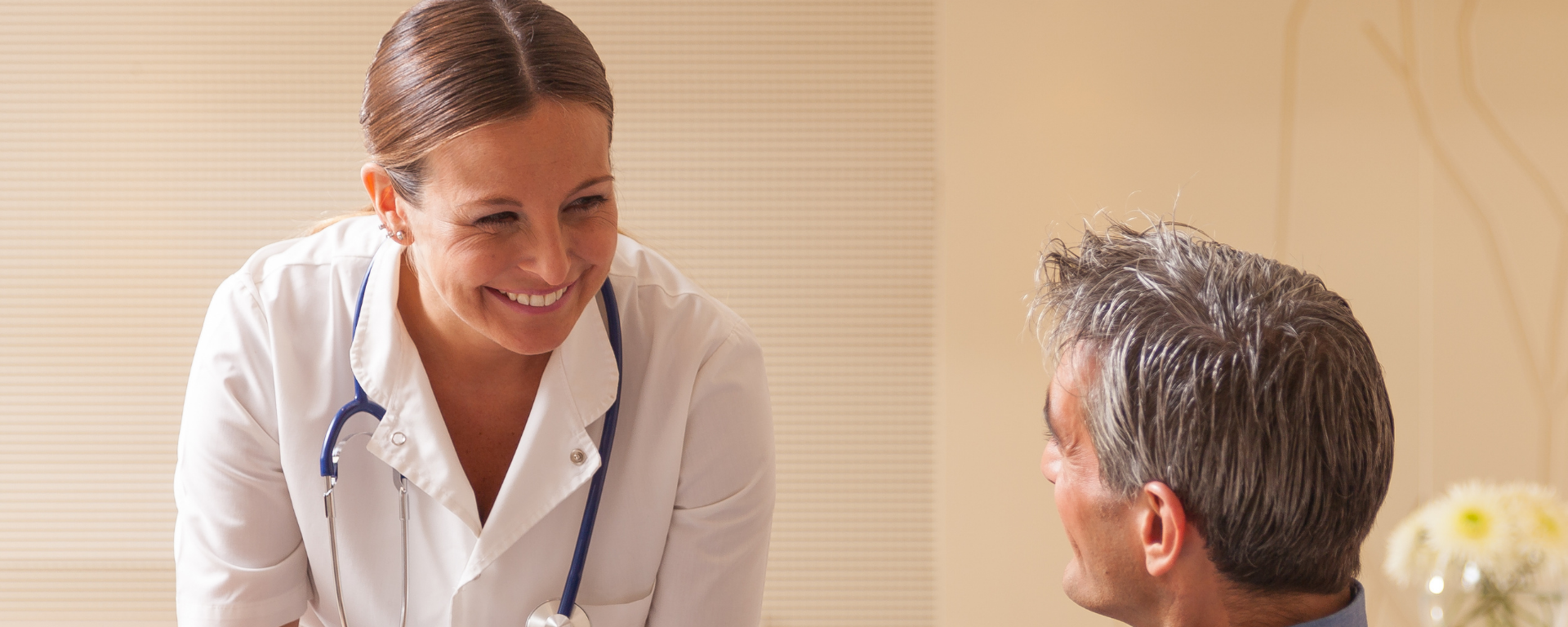 Doctora mira a paciente con una sonrisa